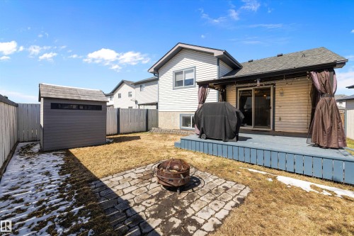 Expansive backyard featuring a blue-painted deck with overhead lighting, a sliding glass door, and privacy curtains - 1811 37 Avenue, Edmonton, AB - Outdoor With Exterior