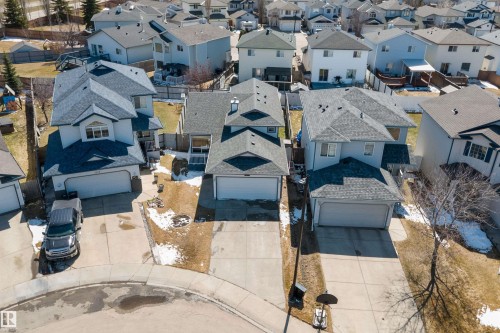Suburban street featuring multiple two-story homes with attached garages, concrete driveways, and sloped backyards - 1811 37 Avenue, Edmonton, AB - Outdoor