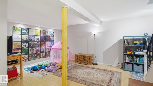 Finished lower level with light wood-finish flooring, recessed lighting, and a prominent structural column - 13533 119 Street, Edmonton, AB - Indoor Photo Showing Other Room