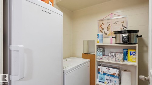 Dedicated utility space featuring a full-size upright freezer, an additional chest freezer, and wall-mounted shelving - 13533 119 Street, Edmonton, AB - Indoor