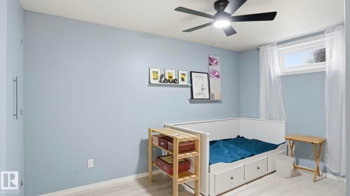 Room featuring light blue walls and wood-finish flooring - 13533 119 Street, Edmonton, AB - Indoor Photo Showing Bedroom