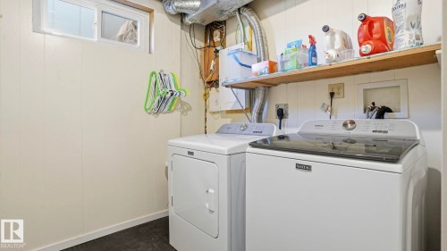 Laundry area featuring a side-by-side washer and dryer, a functional window, and a built-in wood shelf - 13533 119 Street, Edmonton, AB - Indoor Photo Showing Laundry Room