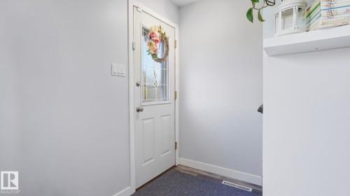 Entry door with decorative glass inserts, chrome hardware, and a white trim surround - 13533 119 Street, Edmonton, AB - Indoor Photo Showing Other Room