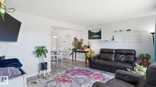 Open-concept living space featuring light gray walls, wood-finish flooring, and crown molding - 13533 119 Street, Edmonton, AB - Indoor Photo Showing Living Room