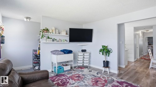 Open-concept living area with light gray walls, wood-finish flooring, and recessed ceiling lighting - 13533 119 Street, Edmonton, AB - Indoor