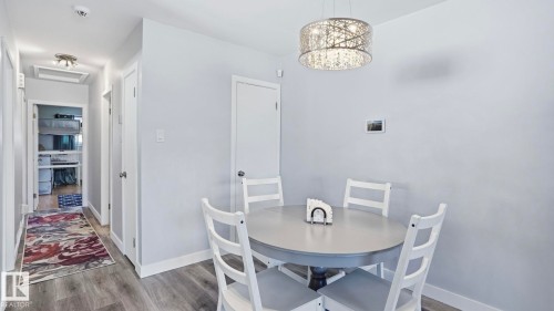 Dining area featuring a contemporary chandelier and wood-finish flooring - 13533 119 Street, Edmonton, AB - Indoor Photo Showing Dining Room
