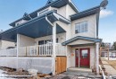 This property features light-colored siding, a covered porch with a white railing, and a red front door - 2 Sturgeon Road, St. Albert, AB  - Outdoor With Deck Patio Veranda 