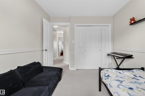 This room features light-colored walls with white trim, wall-to-wall carpeting, and a white bi-fold closet - 2 Sturgeon Road, St. Albert, AB - Indoor Photo Showing Bedroom