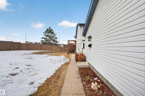 The property features a white exterior with horizontal siding and a pathway leading alongside the building - 2 Sturgeon Road, St. Albert, AB - Outdoor