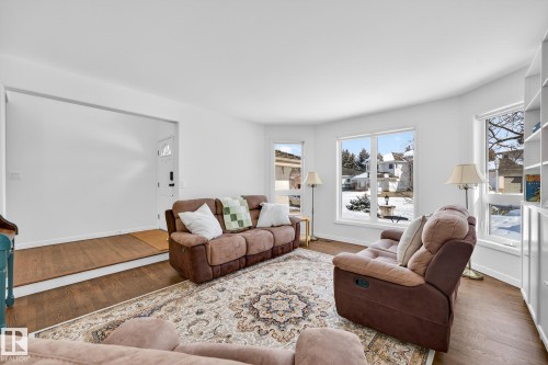 This bright living area features hardwood floors and large windows, providing ample natural light - 1211 Hewgill Place, Edmonton, AB - Indoor Photo Showing Living Room