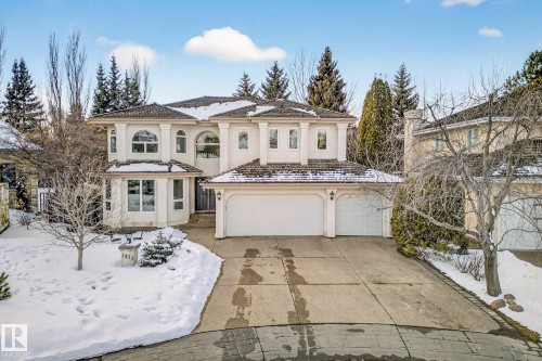 This property features a multi-car garage, a paved driveway, and a snow-covered lawn - 1211 Hewgill Place, Edmonton, AB - Outdoor With Facade