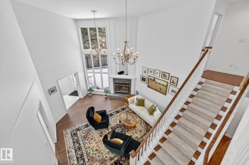 The property features a spacious living area with high ceilings, hardwood floors, and a fireplace - 1211 Hewgill Place, Edmonton, AB - Indoor Photo Showing Other Room With Fireplace