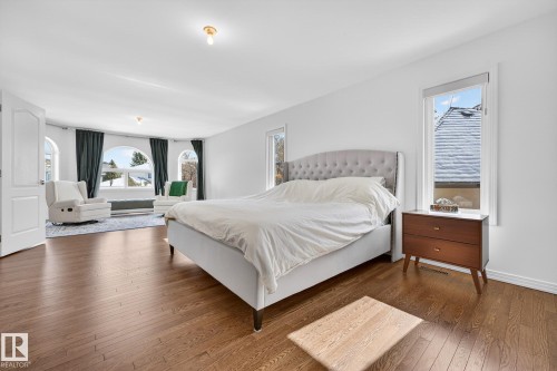 This spacious room features rich hardwood flooring, white walls, and a recessed ceiling light - 1211 Hewgill Place, Edmonton, AB - Indoor Photo Showing Bedroom