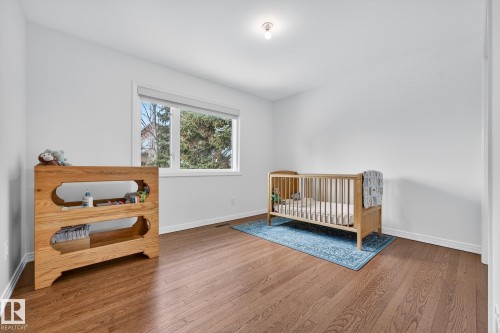 This room features hardwood floors and a window with a view of greenery - 1211 Hewgill Place, Edmonton, AB - Indoor Photo Showing Bedroom