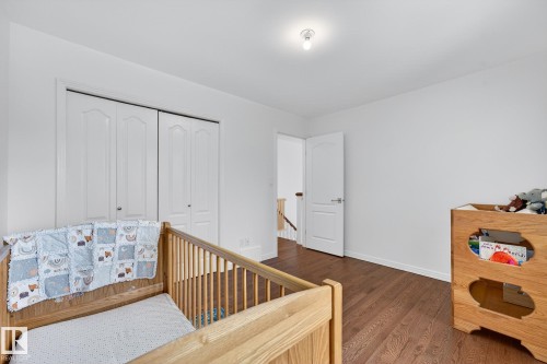 The room features rich hardwood flooring and a white door with a silver handle - 1211 Hewgill Place, Edmonton, AB - Indoor