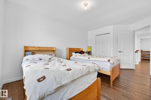 This bedroom features hardwood floors, white walls, and a ceiling light fixture - 1211 Hewgill Place, Edmonton, AB - Indoor Photo Showing Bedroom