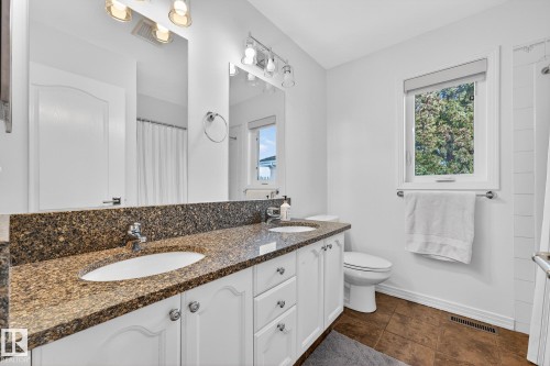 Bathroom featuring a double vanity with granite countertop, white cabinetry, and undermount sinks - 1211 Hewgill Place, Edmonton, AB - Indoor Photo Showing Bathroom