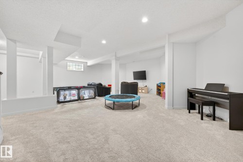 Spacious open room featuring light-colored carpet, recessed lighting, and white walls - 1211 Hewgill Place, Edmonton, AB - Indoor