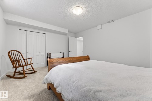 This room features light-colored carpeting, white walls, and a ceiling light fixture - 1211 Hewgill Place, Edmonton, AB - Indoor Photo Showing Bedroom