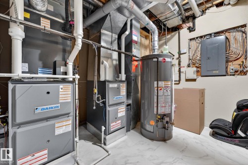 The property features two furnaces, a hot water heater, and an electrical panel - 1211 Hewgill Place, Edmonton, AB - Indoor Photo Showing Basement
