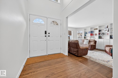 The entry features rich hardwood floors and a double door entrance with decorative glass inserts - 1211 Hewgill Place, Edmonton, AB - Indoor