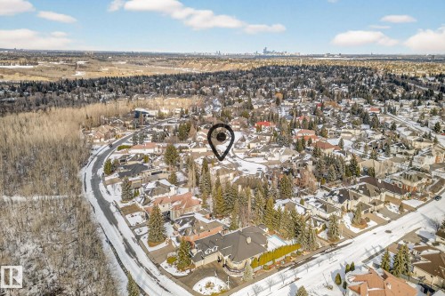 Aerial view of the property's community, featuring extensive tree coverage and a distant city skyline - 1211 Hewgill Place, Edmonton, AB - Outdoor With View