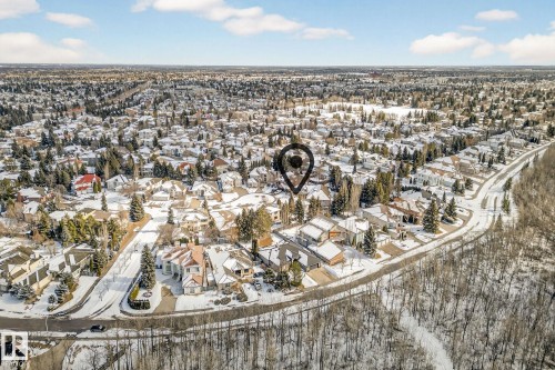 Aerial view of the surrounding residential area featuring a mix of housing styles, abundant mature trees, and snow-covered grounds - 1211 Hewgill Place, Edmonton, AB - Outdoor With View