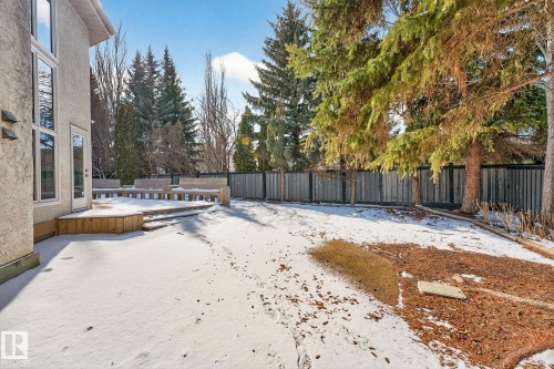 The property features an extensive yard with a wooden fence and mature trees - 1211 Hewgill Place, Edmonton, AB - Outdoor