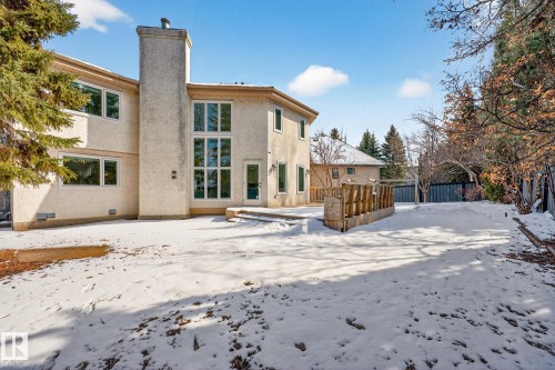 The property features a stucco exterior, a prominent chimney, and a two-story window array - 1211 Hewgill Place, Edmonton, AB - Outdoor
