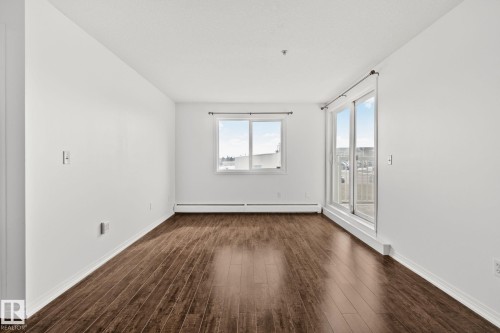 This room features dark wood-style flooring, white walls, and a white ceiling - 105 4309 33 Street, Stony Plain, AB - Indoor Photo Showing Other Room