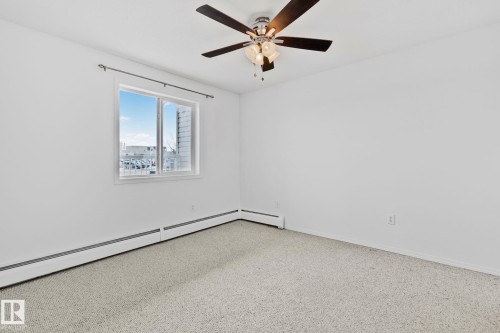 This room features a window providing natural light, a ceiling fan with integrated lighting, and light-colored carpet - 105 4309 33 Street, Stony Plain, AB - Indoor Photo Showing Other Room