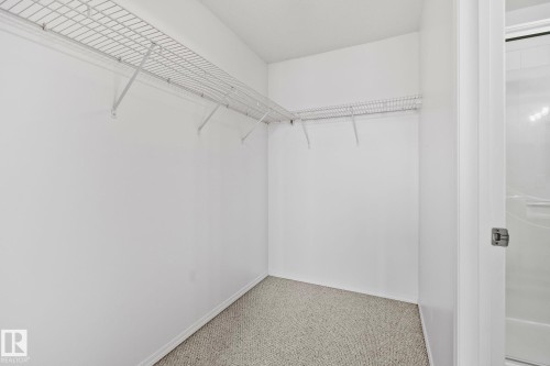 The property features a walk-in closet with carpeted flooring and white wire shelving, offering practical storage solutions - 105 4309 33 Street, Stony Plain, AB - Indoor With Storage