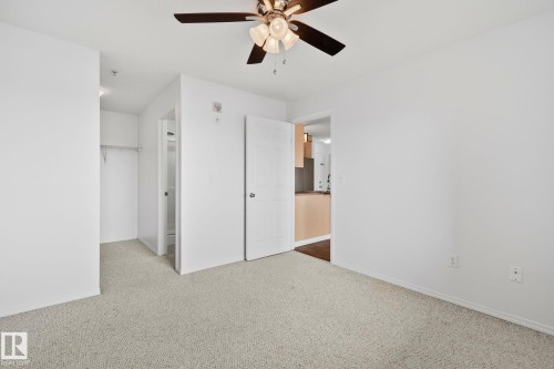 This room features light-colored carpeting, white walls, and a ceiling fan with integrated lighting - 105 4309 33 Street, Stony Plain, AB - Indoor Photo Showing Other Room