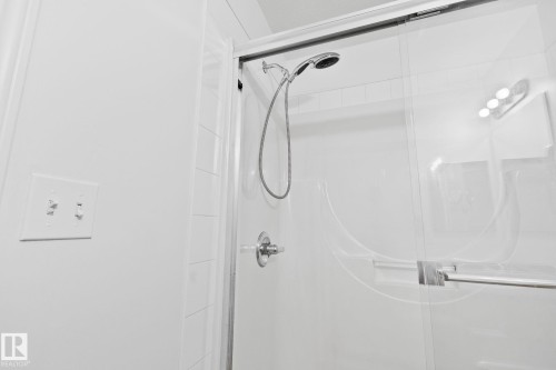 The property features a shower with a handheld shower head and a glass sliding door - 105 4309 33 Street, Stony Plain, AB - Indoor Photo Showing Bathroom