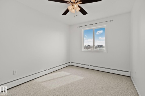 The room features a neutral color palette, a window with an outdoor view, and a ceiling fan with integrated lighting - 105 4309 33 Street, Stony Plain, AB - Indoor Photo Showing Other Room