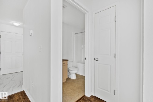 View of a hallway featuring hardwood flooring, white walls, and a white ceiling - 105 4309 33 Street, Stony Plain, AB - Indoor Photo Showing Other Room