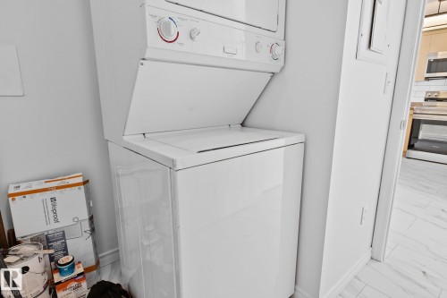 This property features a white stackable washer and dryer unit, providing convenient laundry facilities - 105 4309 33 Street, Stony Plain, AB - Indoor Photo Showing Laundry Room