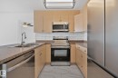 The kitchen features stainless steel appliances, including a microwave, oven, dishwasher, and refrigerator - 105 4309 33 Street, Stony Plain, AB  - Indoor Photo Showing Kitchen With Double Sink 