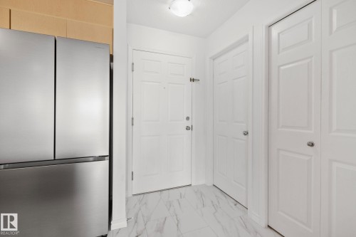 Entryway featuring white paneled doors, a flush mount ceiling light, and marble-look tile flooring - 105 4309 33 Street, Stony Plain, AB - Indoor Photo Showing Other Room