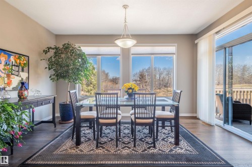 Spacious room featuring multiple windows, a sliding glass door providing exterior access, wood-finish flooring, and a ceiling light fixture - 121 Ellington Crescent, St. Albert, AB - Indoor Photo Showing Dining Room