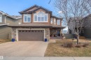 Two-story residence featuring a brown siding exterior, a stone-clad first level, and a covered front porch - 121 Ellington Crescent, St. Albert, AB  - Outdoor With Facade 