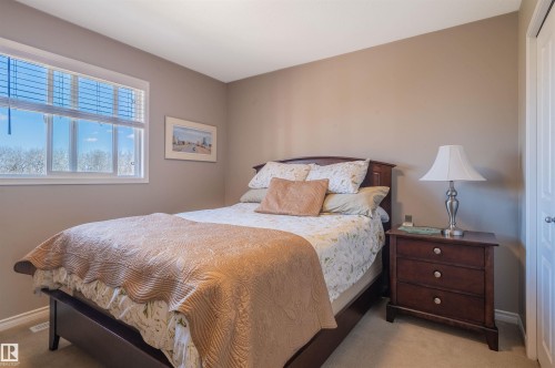 Bedroom featuring a white framed window, neutral wall color, light-colored carpet flooring, and a white paneled door - 121 Ellington Crescent, St. Albert, AB - Indoor Photo Showing Bedroom