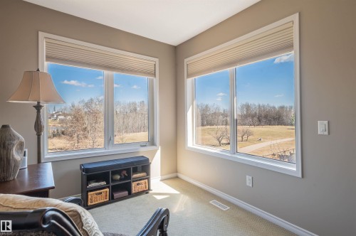 Room featuring a corner window configuration with light-filtering cellular blinds and white trim - 121 Ellington Crescent, St. Albert, AB - Indoor With Fireplace