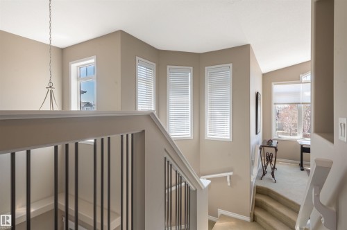 Open-concept upper landing featuring a wrought iron and wood banister, multiple large windows, and neutral wall tones - 121 Ellington Crescent, St. Albert, AB - Indoor Photo Showing Other Room