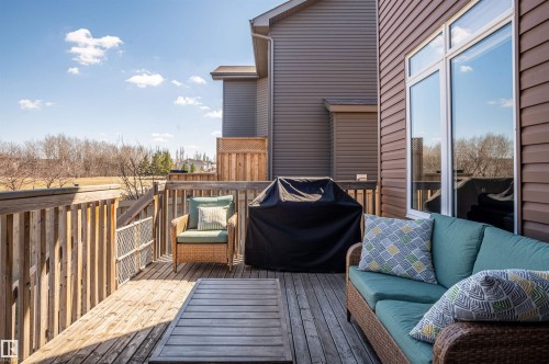 Exterior wood-finish deck with wooden railings, a partial lattice privacy screen, and a multi-pane window with white framing - 121 Ellington Crescent, St. Albert, AB - Outdoor With Deck Patio Veranda With Exterior
