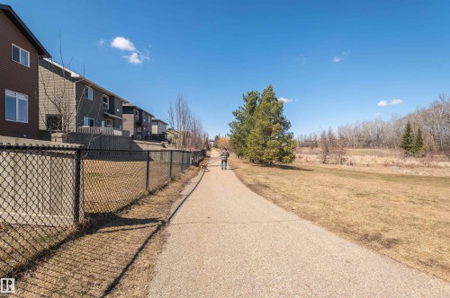 Concrete pathway bordering a chain-link fence and residential properties - 121 Ellington Crescent, St. Albert, AB - Outdoor