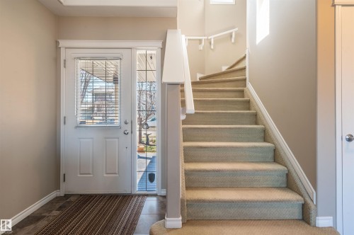 Entryway featuring a white paneled door with integrated blinds, a full-length sidelight, and a curved staircase with a white railing - 121 Ellington Crescent, St. Albert, AB - Indoor Photo Showing Other Room