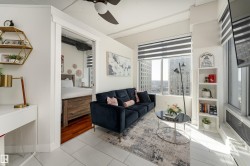 Contemporary living area featuring large windows with horizontal blinds, providing ample natural light - 