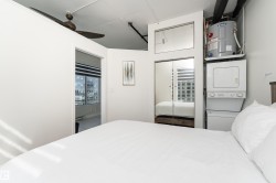 Compact living space featuring white walls and a ceiling fan - 