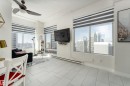 Open-concept living space with light-toned tiled flooring, large windows, ceiling fan, and built-in shelving - 1409 10024 Jasper Avenue, Edmonton, AB  - Indoor Photo Showing Other Room 